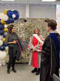 PhD student Angelika Kiss being hooded by her supervisor Michela Ippolito.