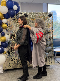 PhD student Angelika Kiss being hooded by her supervisor Michela Ippolito.