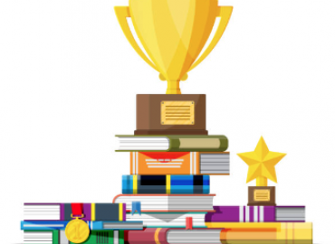 A trophy award sits on a stack of books and papers.