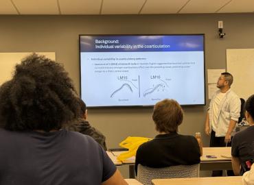 PhD candidate Song Jiang standing in front of his powerpoint presentation. 