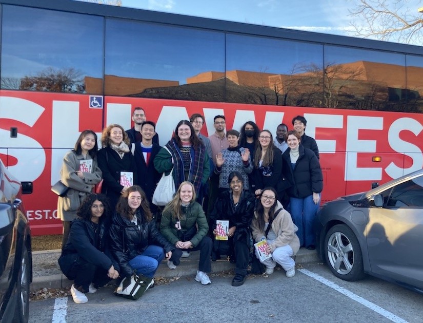 Members of faculty and graduate students pose for a group photo in front of the ShawFest bus taking them to Niagara